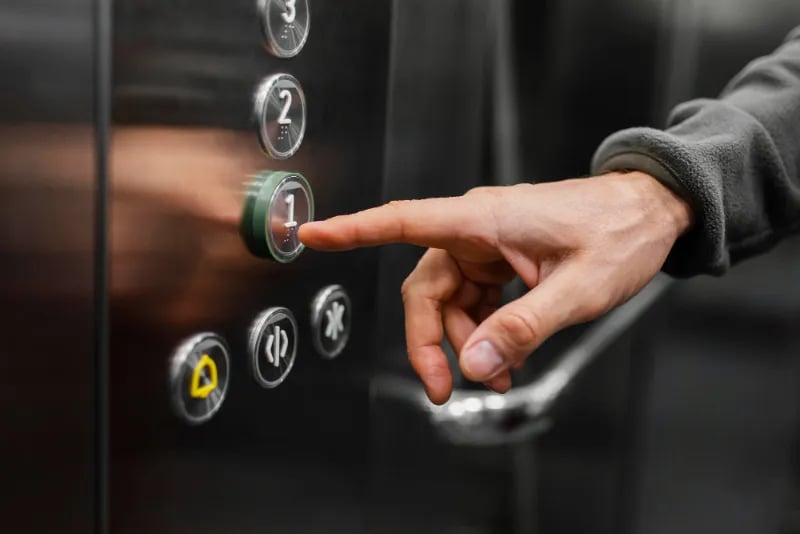 Person choosing a floor button in an elevator