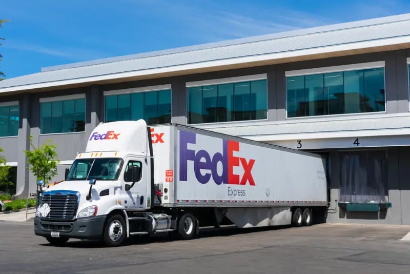 FedEx Express delivery truck unloading at receiving dock of commercial building