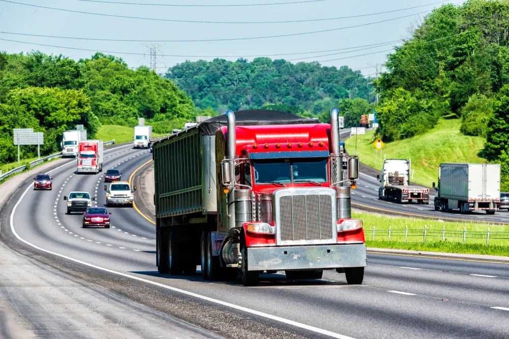 A heavily-loaded semi truck travels the interstate